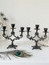 Pair of vintage brass three arm candelabra with scrolling arms and aged patina, photographed on a white surface