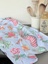 Blue Loft Christmas cotton tea towel with red striped stocking and festive motif pattern photographed on a white worktop.