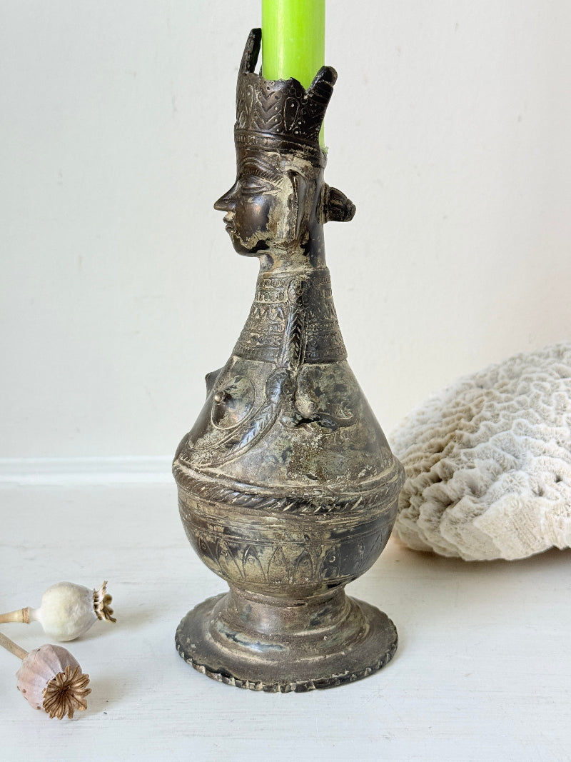 Antique Bengali anthropomorphic brass ritual vessel with goddess figure and lobed headdress, on a white surface