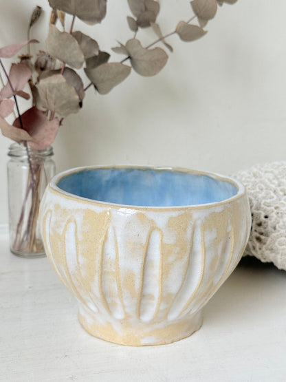 Vintage studio pottery bowl planter in cream and sky blue glaze photographed on a white surface