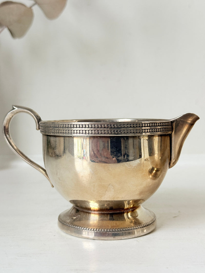Vintage silver plated on brass sugar bowl and milk jug set, photographed on a white surface