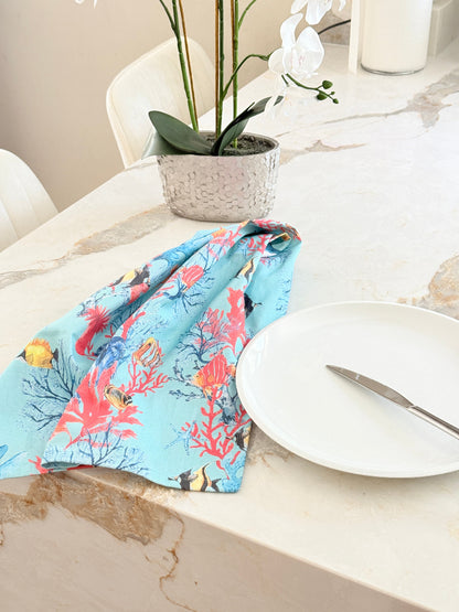 The Blue Loft Caribbean reef print cotton tea towel in turquoise with coral and tropical fish design
