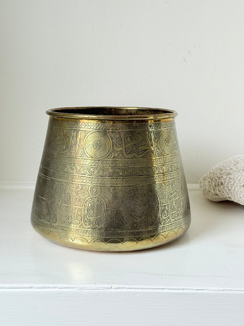 Large vintage brass pot with engraved decoration and aged patina, photographed on a white surface