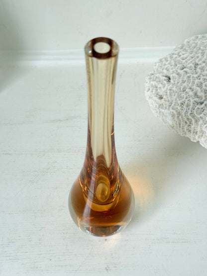 Amber and clear 1960s glass vase with narrow neck and rounded base, photographed on a white surface with dried stems.