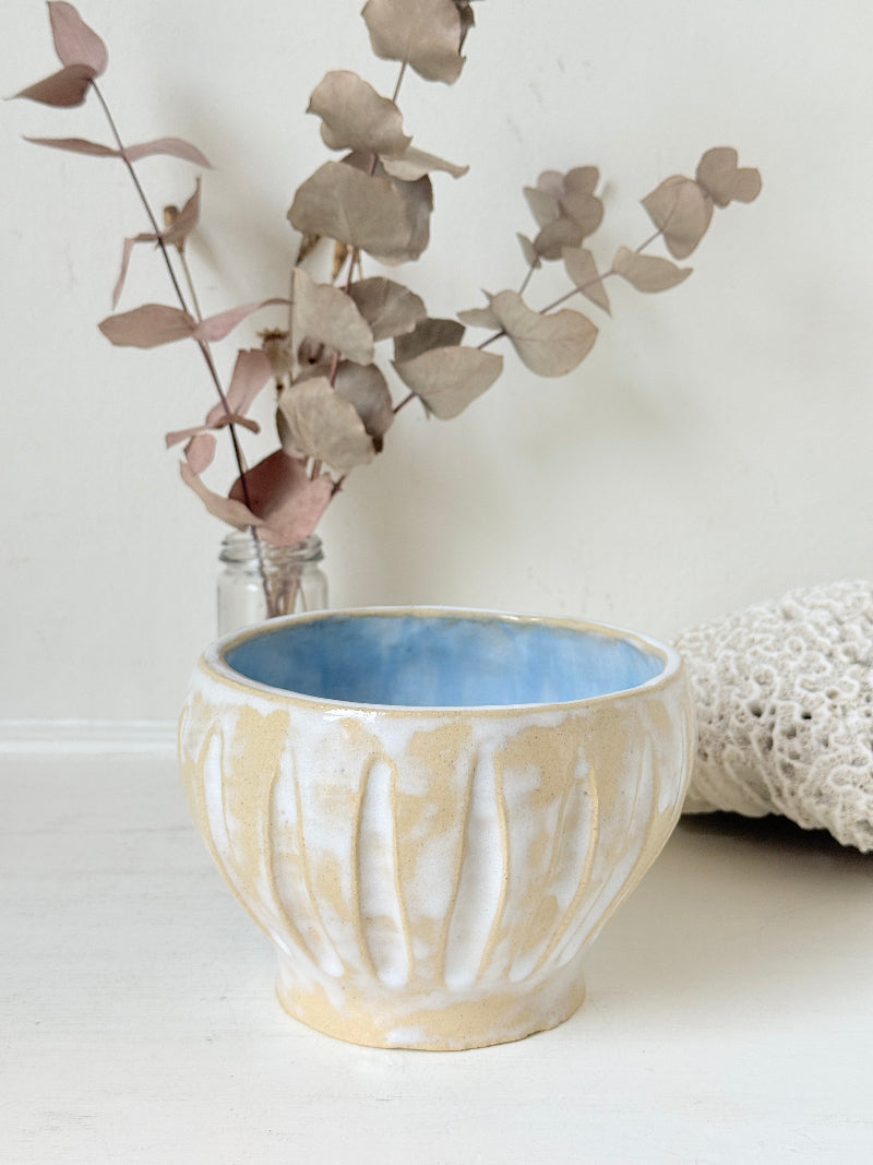 Vintage studio pottery bowl planter in cream and sky blue glaze photographed on a white surface