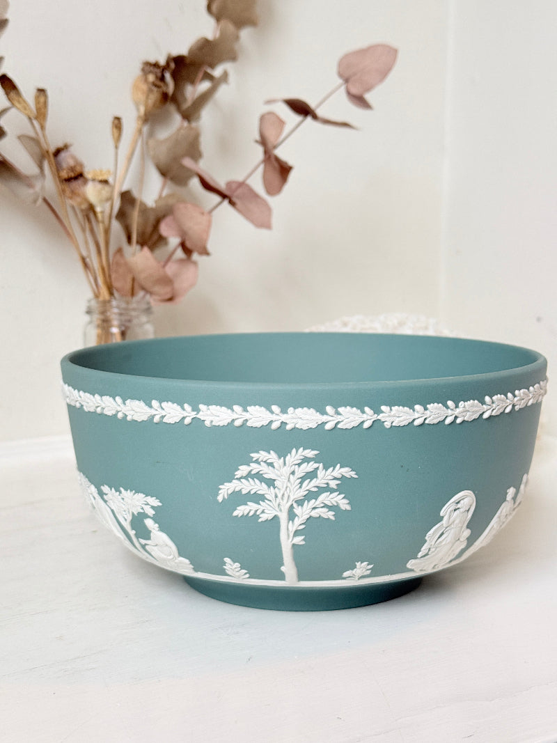 Large vintage Wedgwood Jasperware teal green fruit bowl decorated with white classical figures beneath stylised trees and a laurel garland border.