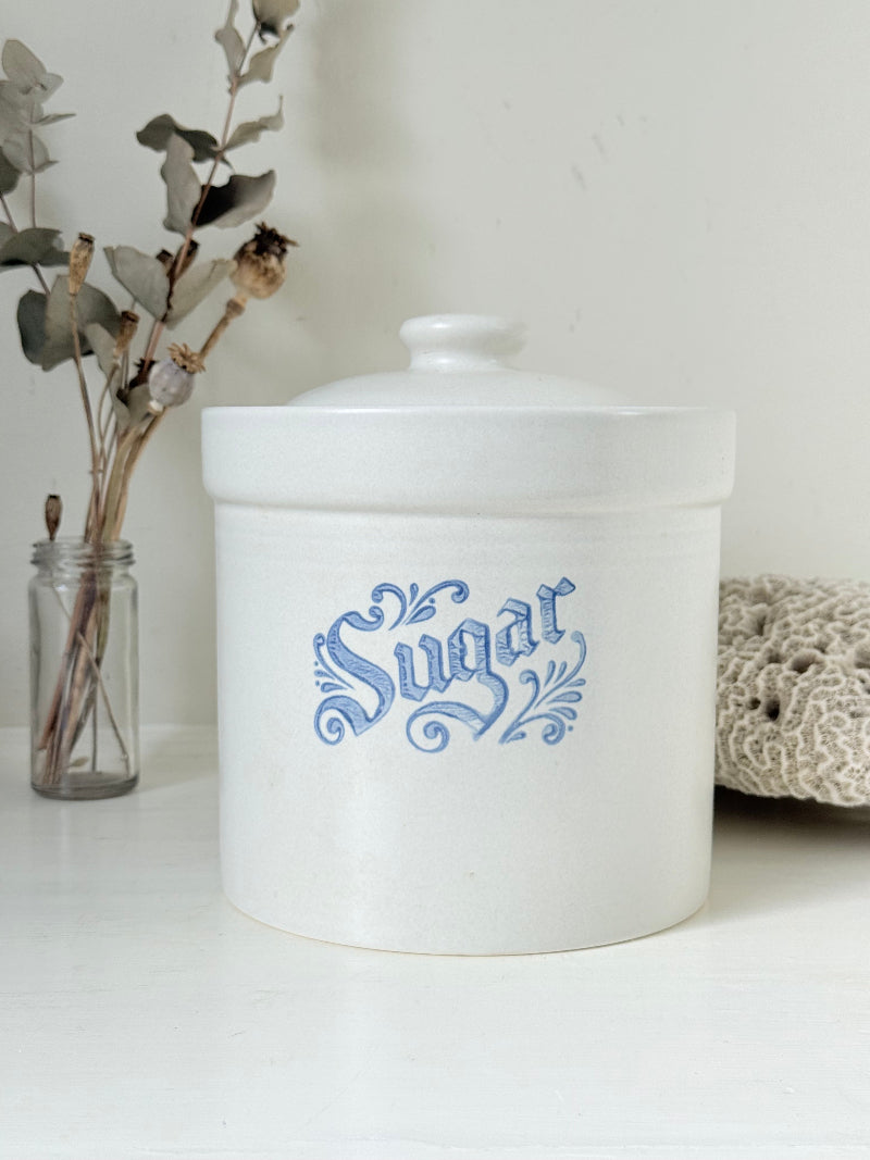 Pfaltzgraff Yorktowne stoneware sugar jar with blue floral motif and lid, photographed on a white surface
