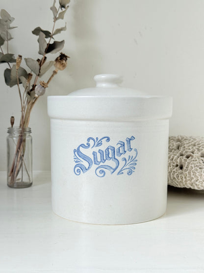 Pfaltzgraff Yorktowne stoneware sugar jar with blue floral motif and lid, photographed on a white surface