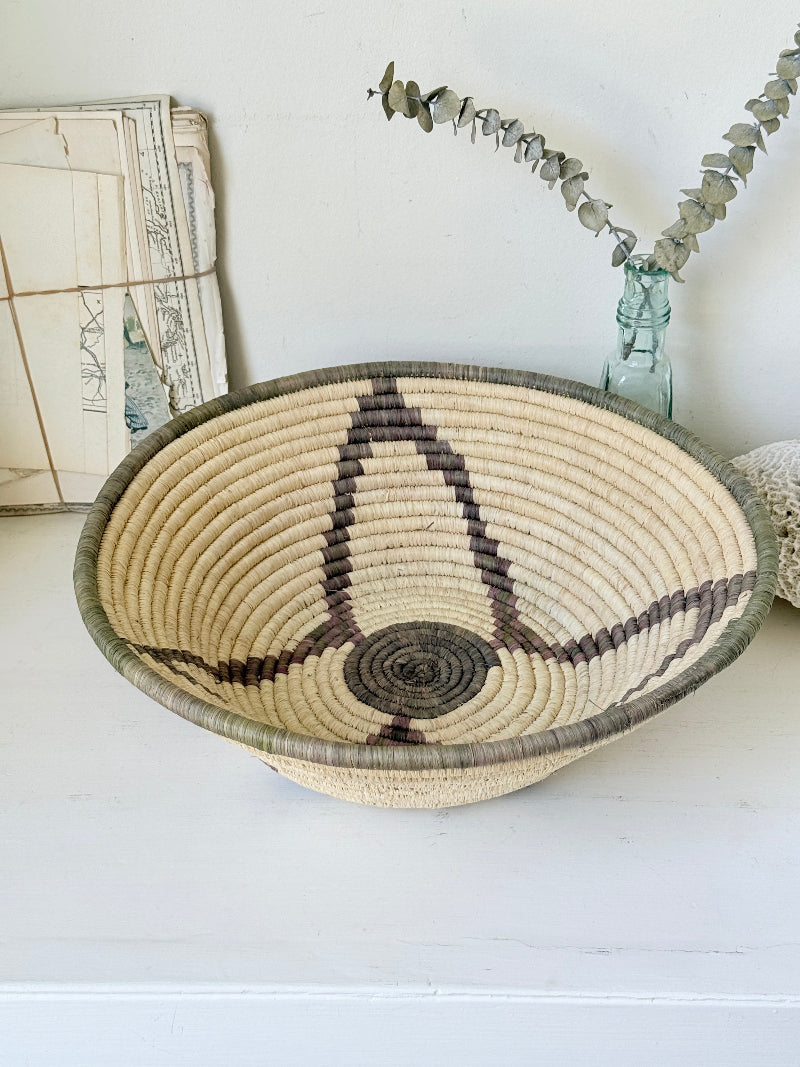 Large hand woven coiled basket with three point star pattern, natural fibre and dark geometric detail for wall or table styling