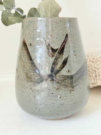 Hand thrown studio pottery vase with ash glaze and brushstroke motif, photographed on white surface
