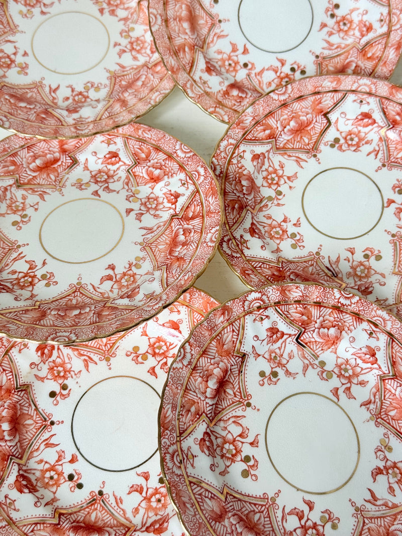 Set of 12 vintage coral transferware porcelain plates with scalloped edges and gold accents, 15 cm diameter, styled on a white surface.