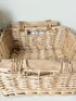 Set of three vintage woven willow baskets in natural tones photographed on a white surface