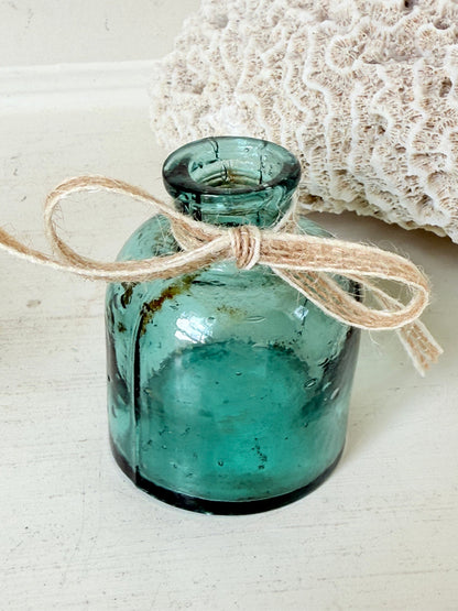 Set of antique green glass ink bottles with rounded forms, photographed on white surface.