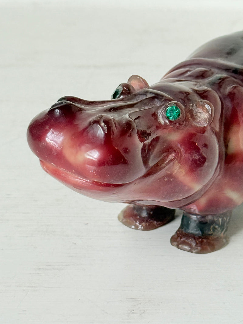 Red polished stone hippopotamus ornament displayed on a white background.