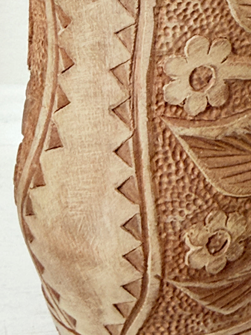Pair of hand carved wooden jug and vase in contrasting light and dark tones, styled with dried poppy heads on a white surface.