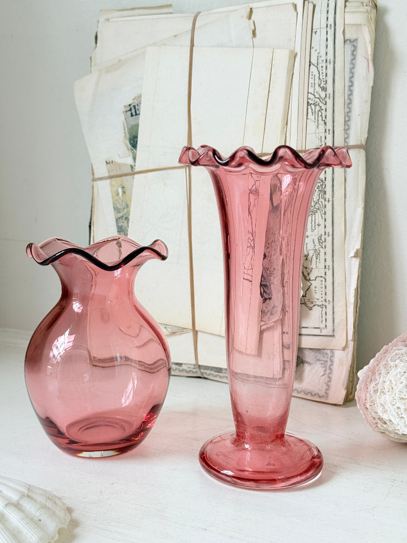 Pair of cranberry glass vases with crimped frill rims, trumpet vase and bulbous bud vase in soft pink glass