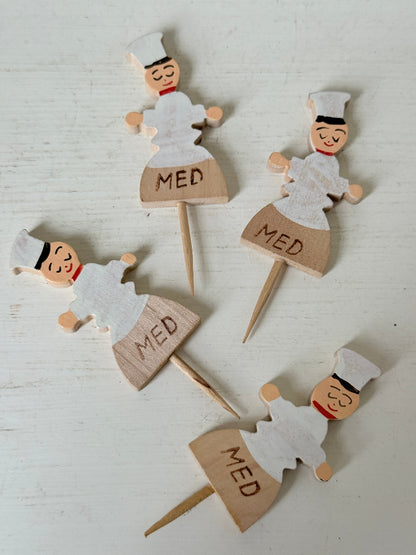 Vintage hand painted wooden steak markers on cocktail sticks labelled rare medium and well done, photographed on a white surface