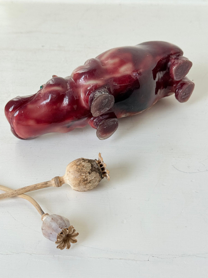 Red polished stone hippopotamus ornament displayed on a white background.