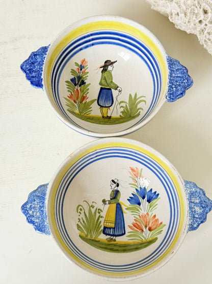Pair of vintage French Quimper Breton figure bowls with blue handles, photographed on a white surface
