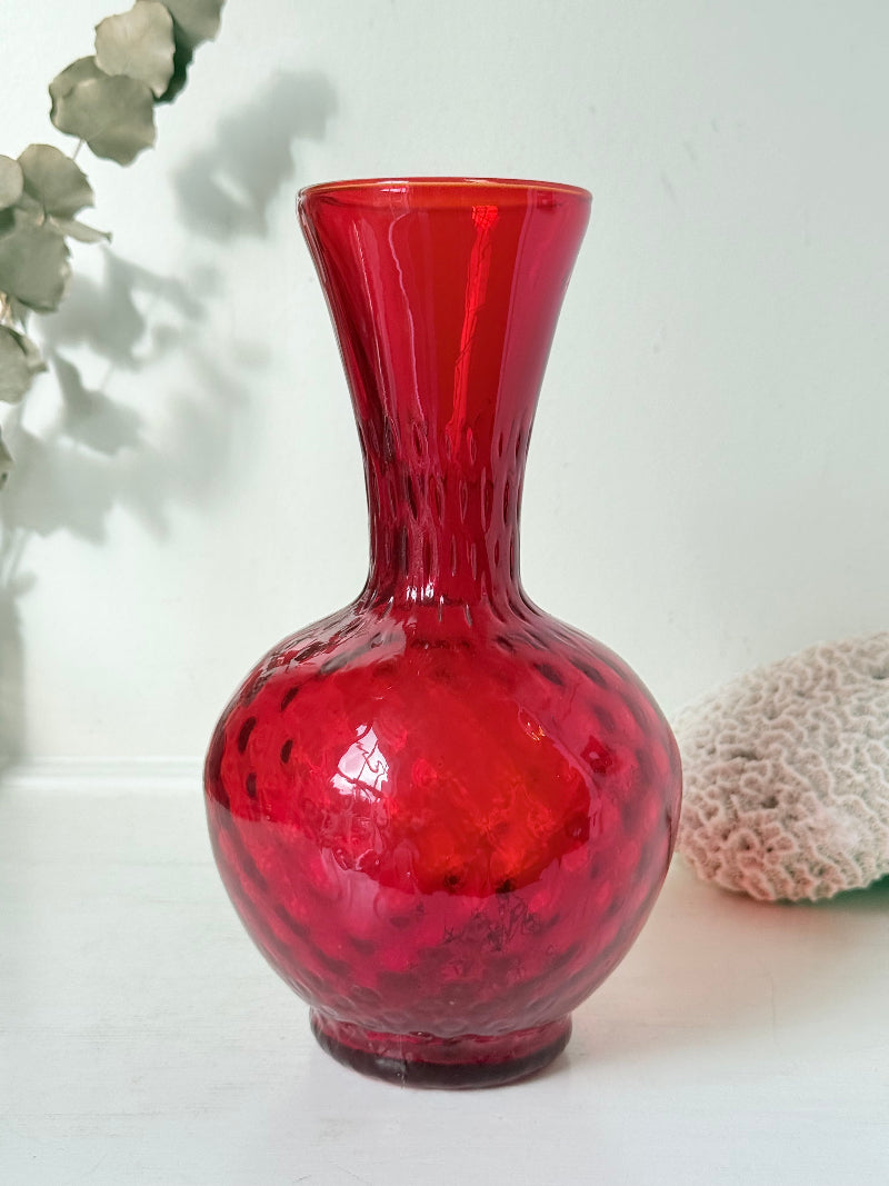 Italian red glass vase with strawberry textured surface, photographed on a white background.