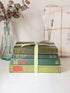 Bundle of vintage sage and olive green cloth books with red spine detail tied with a pale ribbon for styling