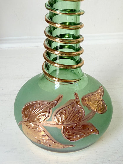 Pair of vintage green glass candlesticks with gold detail and spiral stems styled with blue taper candles on white surface