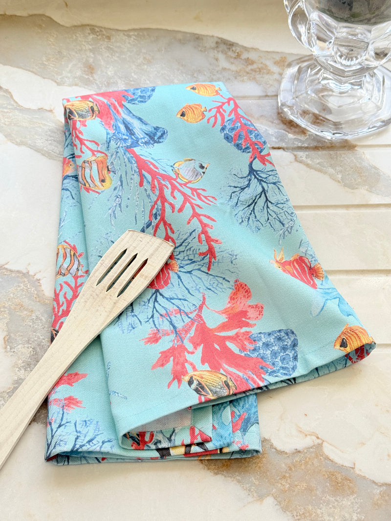 The Blue Loft Caribbean reef print cotton tea towel in turquoise with coral and tropical fish design