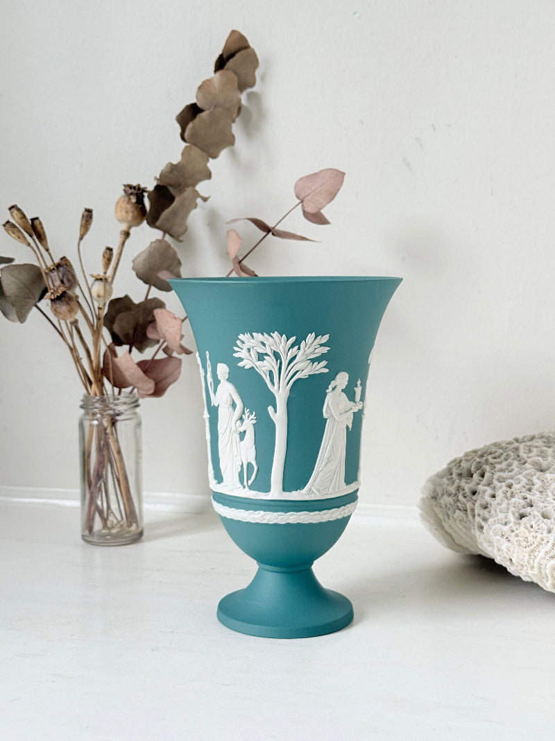 Large vintage Wedgwood Jasperware teal green pedestal vase decorated with white classical Muses figures and stylised trees, styled with dried stems.