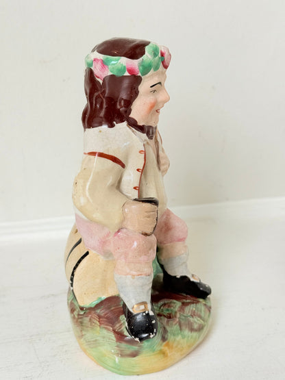 Bacchus antique Staffordshire pottery figure with painted details, photographed on a white surface.