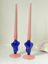 Pair of &Klevering Amsterdam Flux glass candle holders in dark blue and pink with pink taper candles