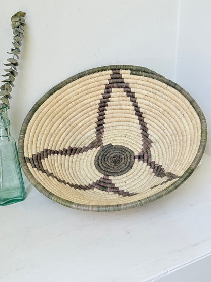 Large hand woven coiled basket with three point star pattern, natural fibre and dark geometric detail for wall or table styling