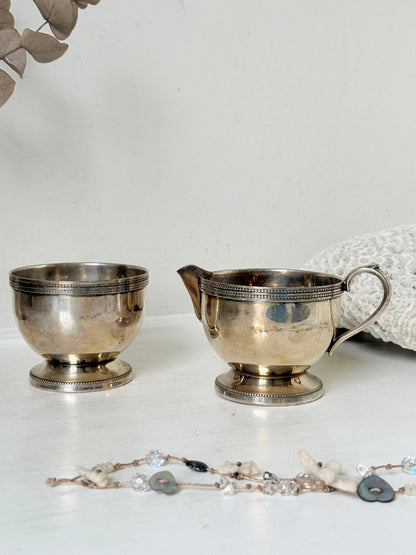 Vintage silver plated on brass sugar bowl and milk jug set, photographed on a white surface