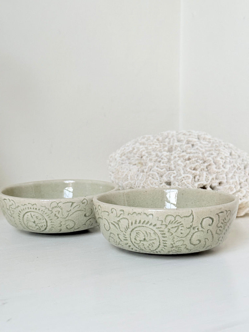 Pair of sage green Thai celadon olive bowls with crackled glaze, photographed on white surface