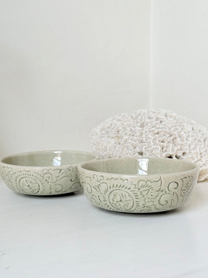 Pair of sage green Thai celadon olive bowls with crackled glaze, photographed on white surface