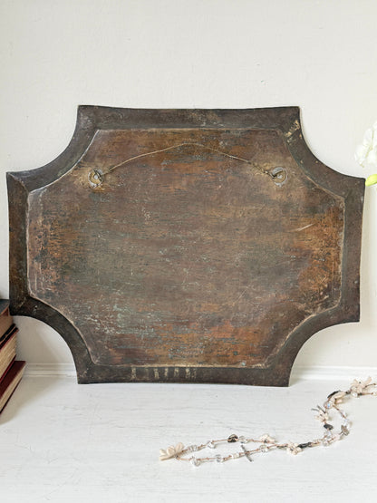 Vintage hand engraved brass wall plaque with floral scrollwork, figural decoration, shaped edge and aged patina