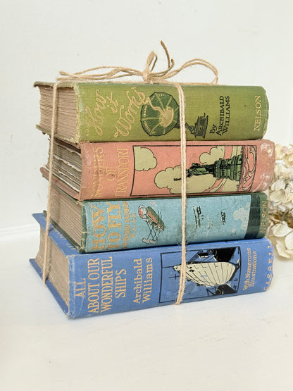 Vintage decorative book bundle in green, blue, and coral with printed lettering, tied with twine, photographed on a white surface