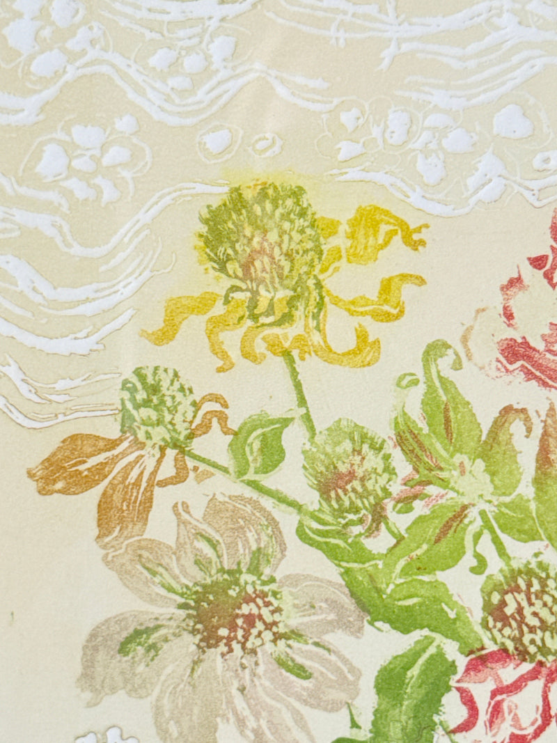 A close-up of a floral fabric pattern featuring yellow, green, and pink flowers on a warm beige background with a white wavy pattern.
