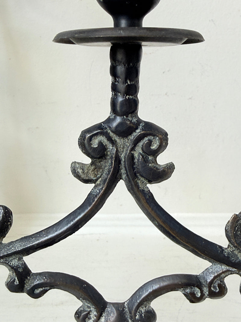 Pair of vintage brass three arm candelabra with scrolling arms and aged patina, photographed on a white surface