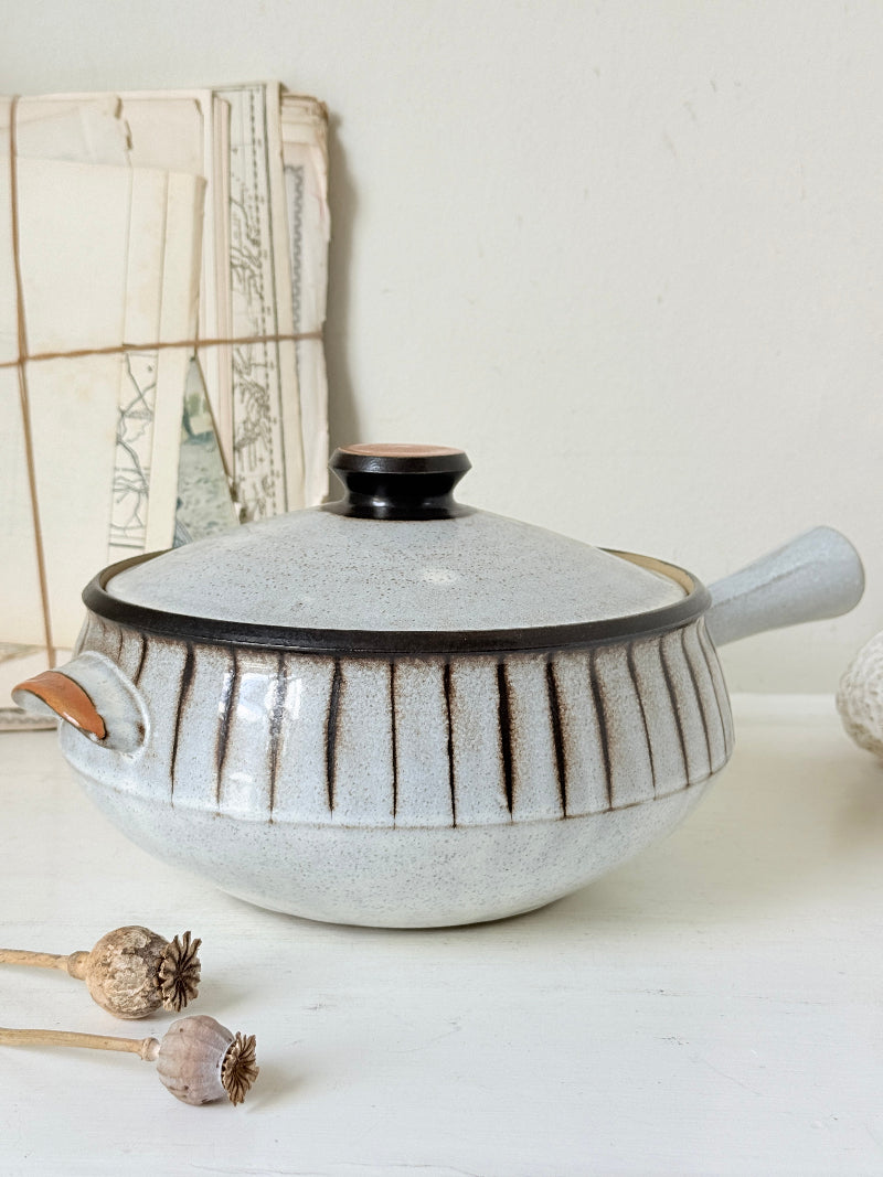 Denby Studio large two handled lidded casserole in grey and rust photographed on a white surface