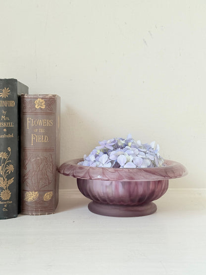Davidson Cloud Glass bowl in amethyst with swirl pattern and footed base, styled with books and hydrangeas