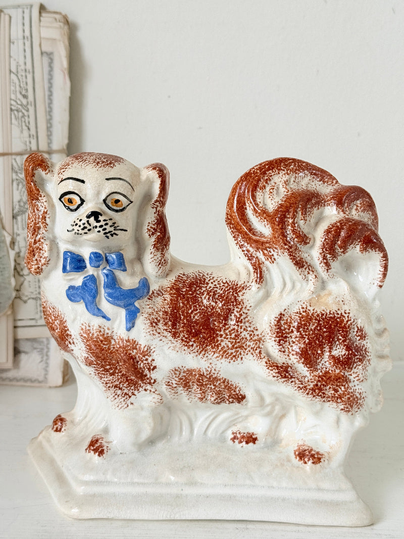 Pair of antique standing Staffordshire Pekingese dogs in rust red and white with blue painted bows