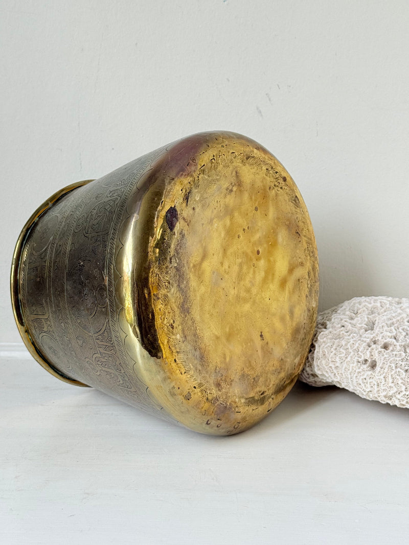 Large vintage brass pot with engraved decoration and aged patina, photographed on a white surface