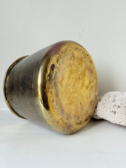 Large vintage brass pot with engraved decoration and aged patina, photographed on a white surface