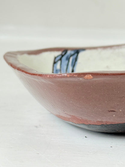 Vintage studio pottery soap dish with hand painted blue bird motif and terracotta rim, photographed on a white surface