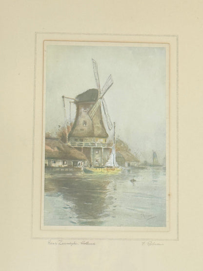 framed print of dutch windmill beside water in holland with reflection photographed on white surface