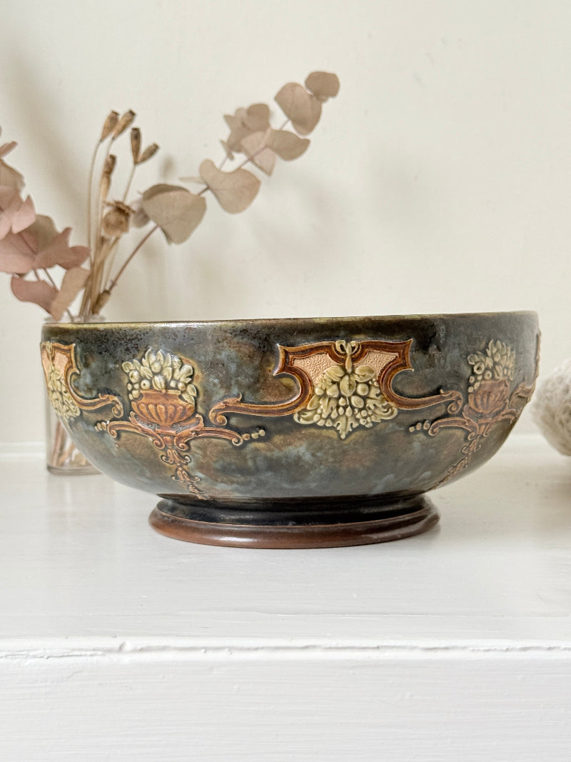 Antique Royal Doulton stoneware fruit bowl with relief floral decoration, photographed on a white surface