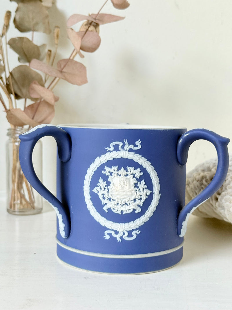 Adam’s blue jasperware loving cup with white classical relief decoration photographed on a white surface.