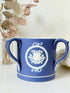 Adam’s blue jasperware loving cup with white classical relief decoration photographed on a white surface.