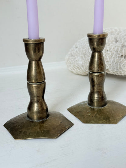 Pair of miniature brass candlesticks with hex bases photographed on a white surface