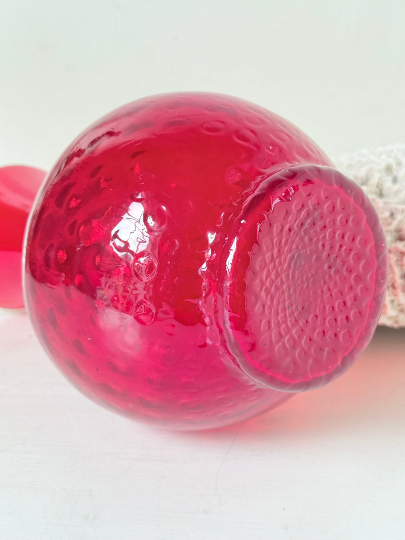 Italian red glass vase with strawberry textured surface, photographed on a white background.